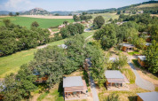 Aerial view of wooden cabins in the lush landscape at Huttopia Pays de Cordes sur Ciel, Occitanie, France.