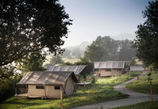 Udsigt over glampingtelte blandt træer og natur i Huttopia Pays de Cordes sur Ciel, Occitanie, Frankrig.