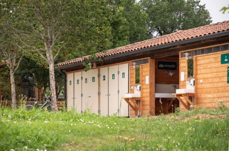 Sanitary building and dishwashing station at Huttopia Pays de Cordes sur Ciel holiday park in Occitanie, France.
