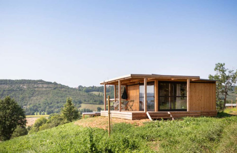 Cabaña de madera en Huttopia Pays de Cordes sur Ciel, parque vacacional en Occitanie, Francia, con vistas.