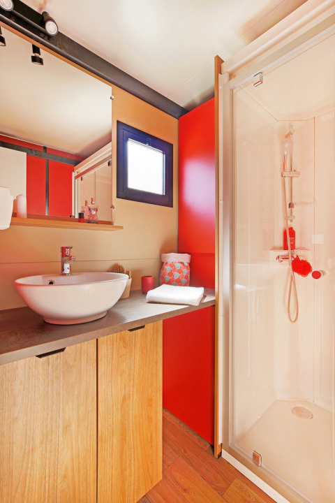 Moderne badkamer met houten meubel, ronde wastafel, grote spiegel en douche in Chalet Evasion Vista.