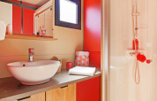 Baño moderno con armario de madera, lavabo redondo, espejo grande y ducha en Chalet Evasion Vista.