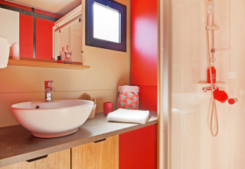 Moderne badkamer met houten meubel, ronde wastafel, grote spiegel en douche in Chalet Evasion Vista.