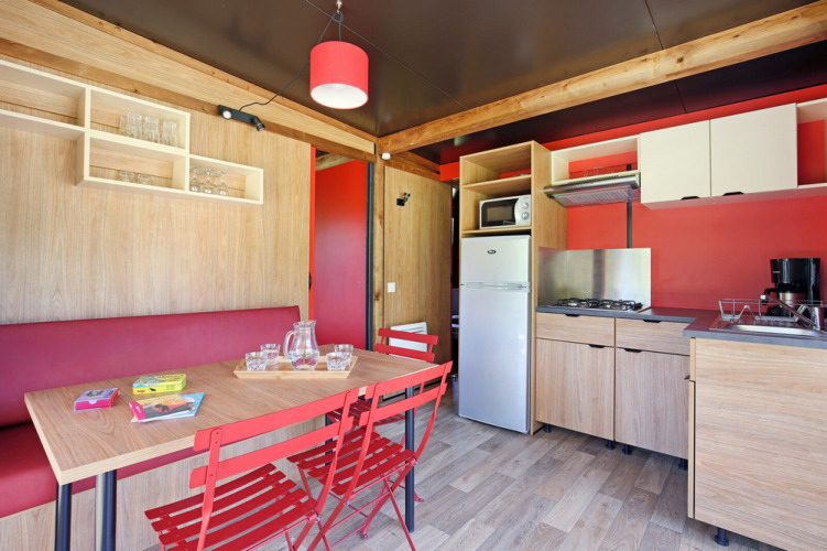 Moderne keuken en eethoek in Chalet Evasion Vista met rode accenten en houten meubels.