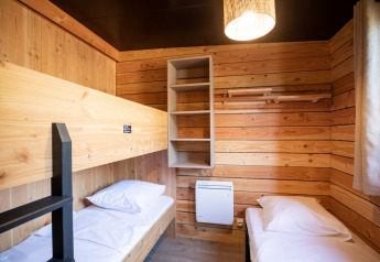 Vista interior de la cabaña Chalet Evasion Vista en Huttopia De Roos, Países Bajos, con dos camas individuales.