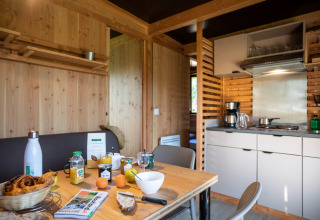 Gezellige keuken en eetruimte in Chalet Evasion Vista met ontbijt en interieur van lichte houtsoorten.