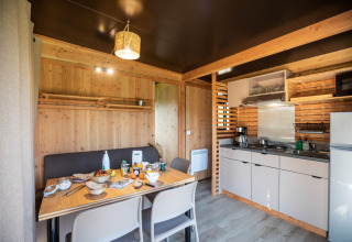 Vista interior del Chalet Evasion Vista en Huttopia De Roos, Países Bajos, con cocina y comedor.