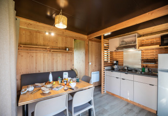 Vista interior del Chalet Evasion Vista en Huttopia De Roos, Países Bajos, con cocina y comedor.