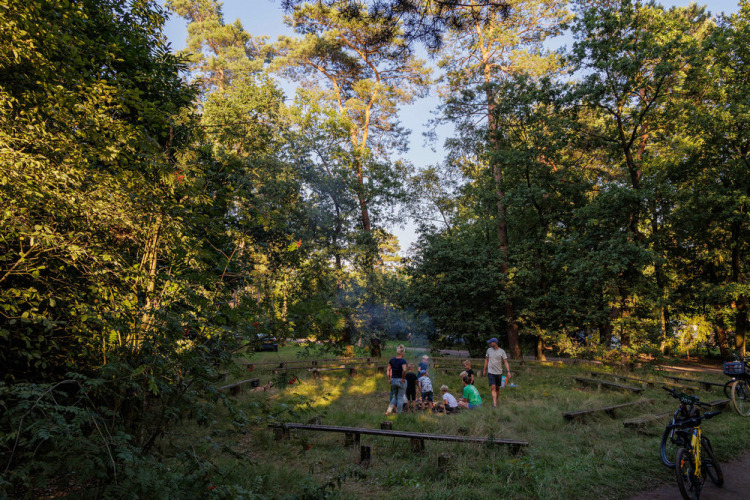 Familles autour d’un feu de camp au Camping Huttopia De Veluwe, parc de vacances en forêt à Gelderland, Pays-Bas.