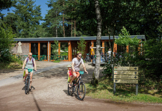 Gezin fietst bij Camping Huttopia De Veluwe, een vakantiepark midden in de natuur van Gelderland.
