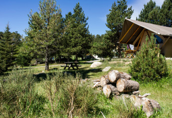 Safari tent Canadienne Cosy at Camping Huttopia De Veluwe, Netherlands, with picnic table and firewood.