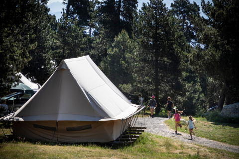 Family camps in a Canadienne Cosy safari tent at Camping Huttopia De Veluwe, surrounded by forest scenery.