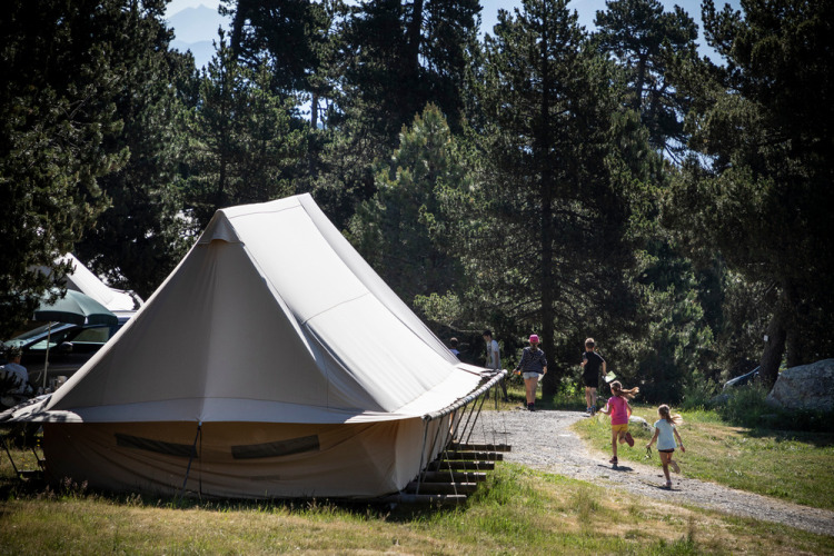 Familie erkundet Campingplatz bei einem Canadienne Cosy Safarizelt in Camping Huttopia De Veluwe, Niederlande.
