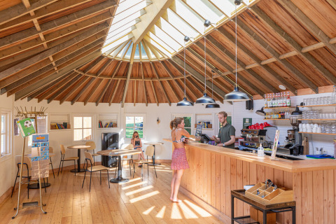 Interno di una caffetteria a Huttopia De Roos, parco vacanze a Overijssel, Paesi Bassi, con soffitto in legno