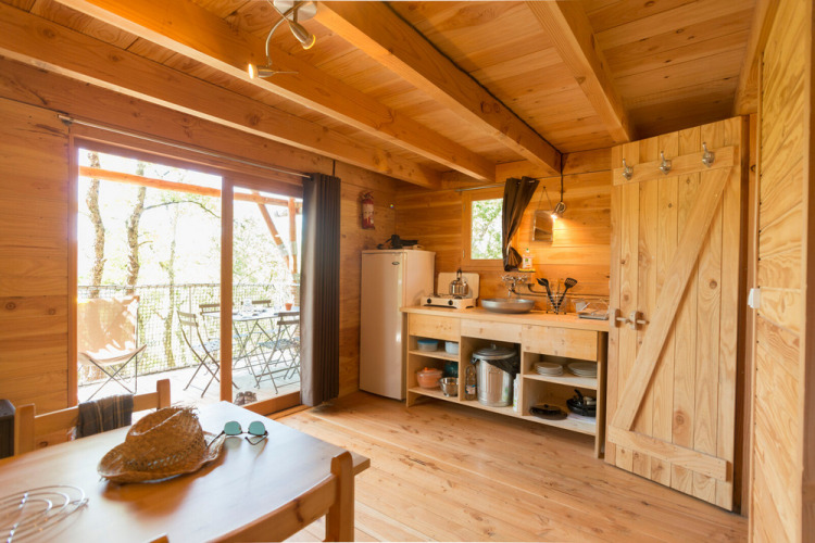 Vista interior de la tienda safari Cahutte en Huttopia De Roos, Países Bajos, con acabados de madera.
