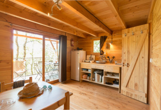 Vista interior de la tienda safari Cahutte en Huttopia De Roos, Países Bajos, con acabados de madera.