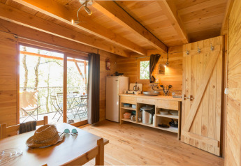 Vista interior de la tienda safari Cahutte en Huttopia De Roos, Países Bajos, con acabados de madera.