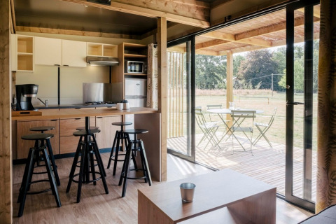 Indvendig udsigt fra Chalet Toronto, Huttopia De Roos, Holland, med moderne køkken og terrasseområde.