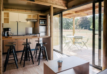 Vista interior del Chalet Toronto en Huttopia De Roos, Países Bajos, con cocina moderna y área de terraza.