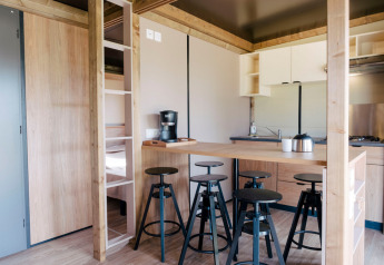 Moderne indretning af Chalet Toronto i Huttopia De Roos, Nederlandene, med køkken og barstole.