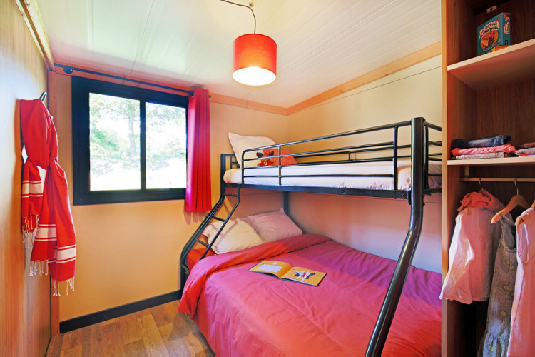 Acogedora habitación en Chalet Toronto de Huttopia De Roos, Países Bajos, con litera y decoración viva.