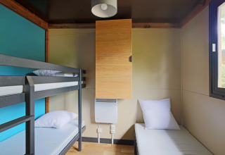 Moderne glamping accommodatie bij Chalet Evasion met stapelbed, enkel bed, kast en raam.