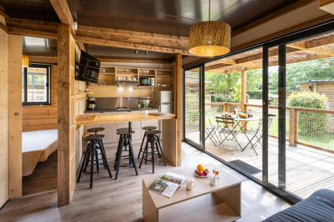 Modern glamping Chalet Portland met licht houten interieur, open keuken en een ruime gemeubileerde veranda.
