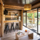 Moderne glamping Chalet Portland med lyst træinteriør, åbent køkken og stor terrasse med havemøbler.