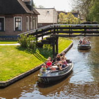 Personas navegando en botes por un canal en una pintoresca aldea cerca de Kallenkote, Overijssel, Países Bajos.