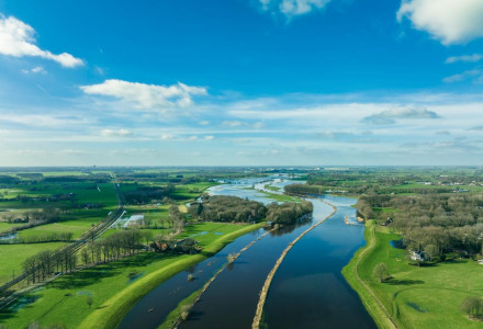 Vista aérea del paisaje verde y el río cerca de Beerze-Ommen en Overijssel, Países Bajos, bajo cielo azul.