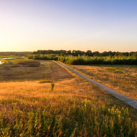Paisaje rural con campos, un camino y un río cerca de Beerze-Ommen, Overijssel, Países Bajos, al atardecer.