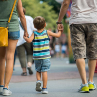 Eine Familie spaziert Hand in Hand durch die Straßen nahe Kootwijk, Gelderland, Niederlande an einem sonnigen Tag.