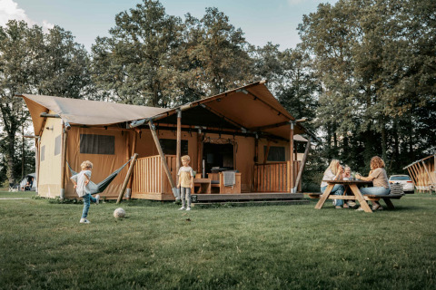Famiglia che si gode le attività all'aperto davanti a una tenda glamping a Camping de Italiaanse Meren.
