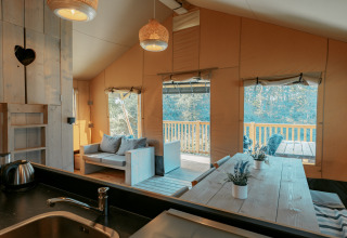 Interior de una cabaña en Camping de Italiaanse Meren, Países Bajos, con detalles en madera y terraza.