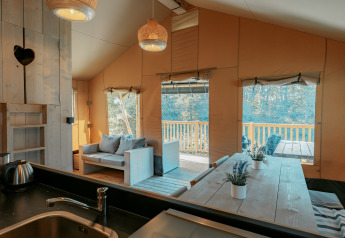 Interior de una cabaña en Camping de Italiaanse Meren, Países Bajos, con detalles en madera y terraza.