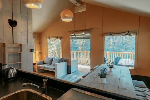 Interior de una cabaña en Camping de Italiaanse Meren, Países Bajos, con detalles en madera y terraza.