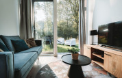 Modernes Wohnzimmer der Oslo Suite mit Gartenblick im Camping de Italiaanse Meren in den Niederlanden.