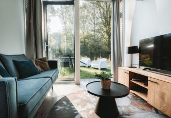 Moderne stue i Oslo Suite med udsigt til grøn have ved Camping de Italiaanse Meren i Holland.