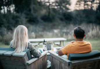 To personer sidder udenfor ved Oslo Suite, Camping de Italiaanse Meren i Holland, og nyder naturen.