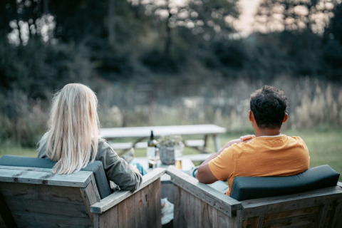 Twee mensen zitten buiten bij de Oslo Suite op Camping de Italiaanse Meren in Nederland en genieten van het uitzicht.