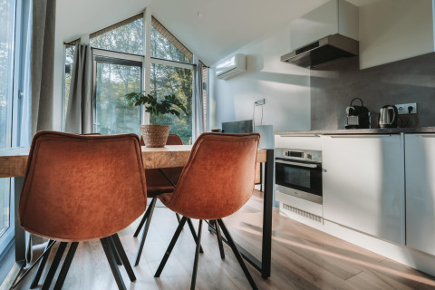 Moderne eethoek met keuken in de Oslo Suite bij Camping de Italiaanse Meren in Nederland.