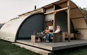 To personer slapper af på terrassen ved en Arcade-lodge på Camping de Italiaanse Meren i Holland.