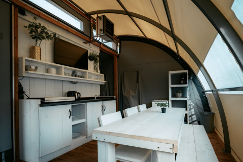 Intérieur du lodge Arcade au Camping de Italiaanse Meren aux Pays-Bas, avec cuisine et coin repas.