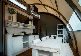 Interior de la Arcade lodge en Camping de Italiaanse Meren, Países Bajos, con cocina y comedor visibles.