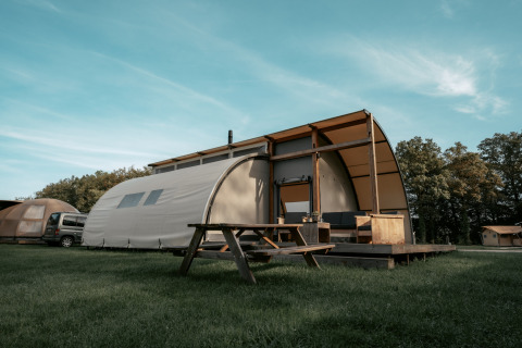 Lodge Arcade en Camping de Italiaanse Meren en Países Bajos, con terraza de madera y mesa de picnic exterior.