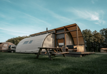 Arcade-Lodge am Campingplatz de Italiaanse Meren in den Niederlanden mit Holzterrasse und Picknicktisch.