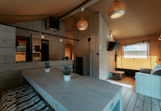 Hyggelig indretning af Ranger Lodge ved Camping de Italiaanse Meren, Holland, med træpaneler og moderne møbler.