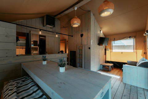 Hyggelig indretning af Ranger Lodge ved Camping de Italiaanse Meren, Holland, med træpaneler og moderne møbler.