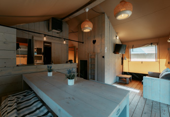 Cozy interior of Ranger Lodge at Camping de Italiaanse Meren in the Netherlands featuring wooden decor and seating.