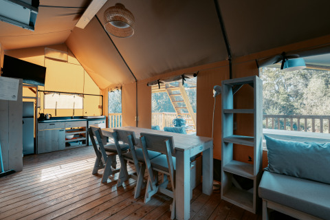Intérieur de la Ranger Lodge au Camping de Italiaanse Meren, Pays-Bas, avec table à manger et cuisine.